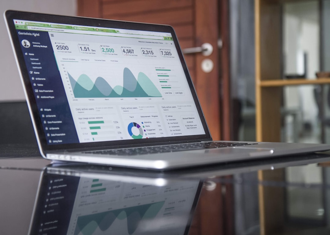 Laptop showing market charts and analytics on a wooden desk.